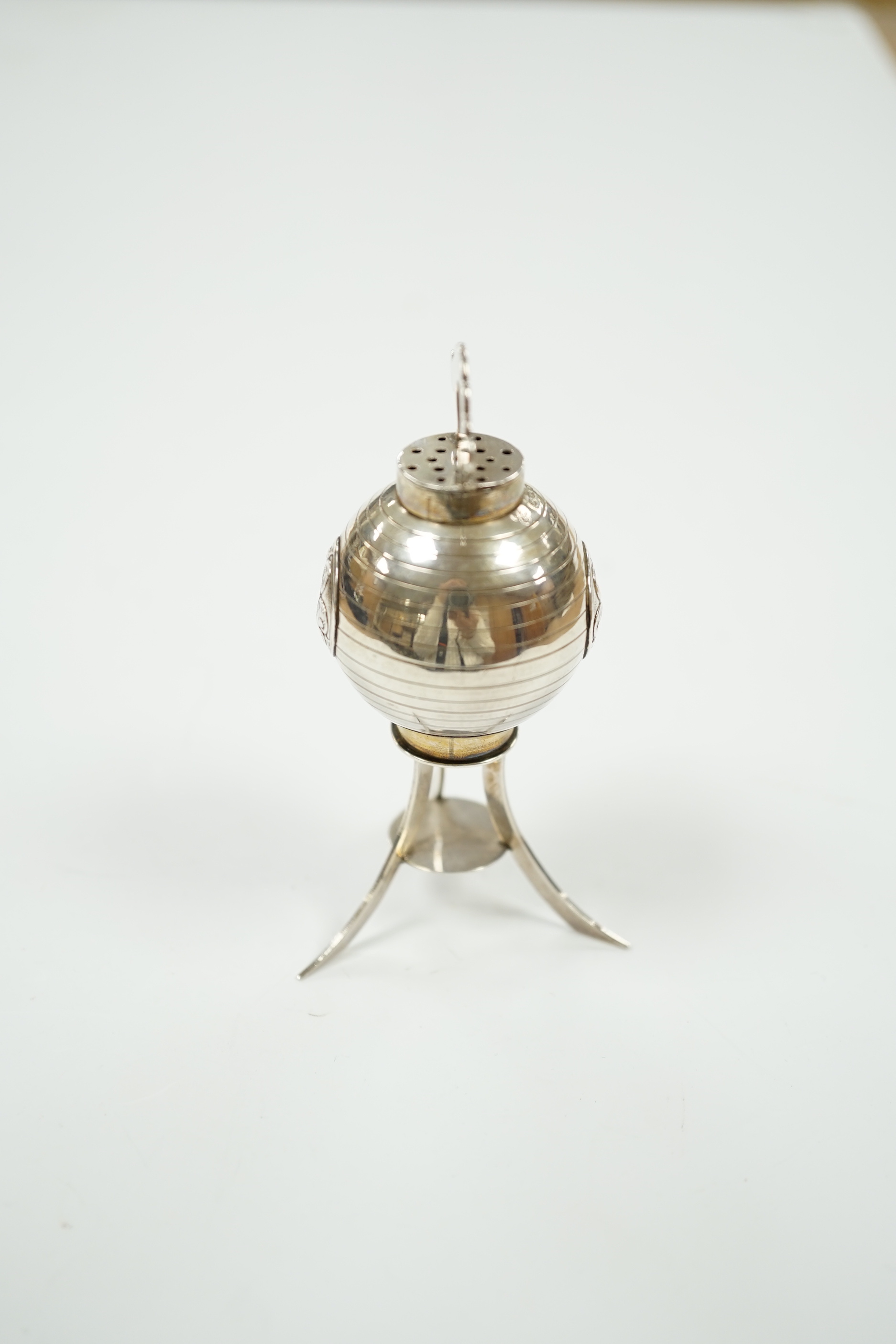 A 1920's continental silver pepperette, on tripod support, stamped sterling, import marks for London, 1920, 82mm.